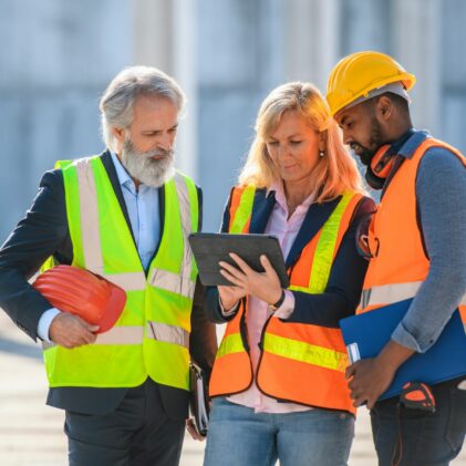 Construction project manager looking at a computer with the team
