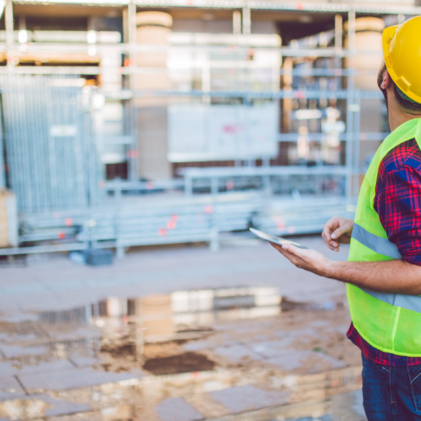 General contractor on a tablet on jobsite usuing construction inspection and management software.
