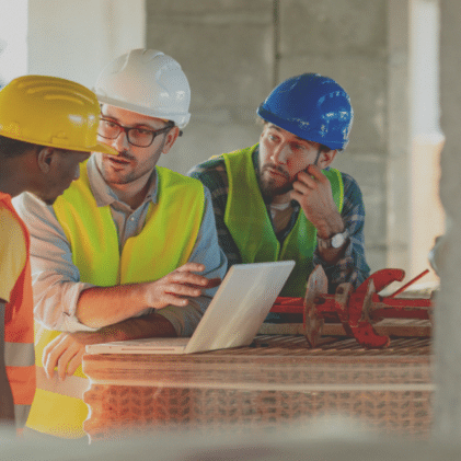 A group of construction project owners looking over a computer.